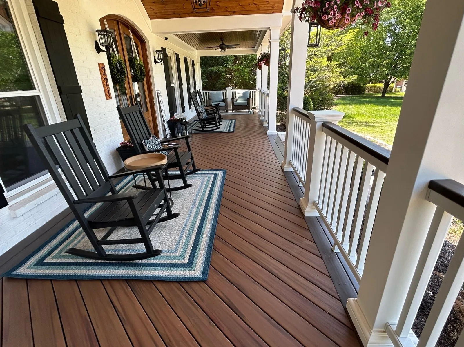 Wrap-around front porch with composite decking, white columns and rocking chairs on a Tennessee home